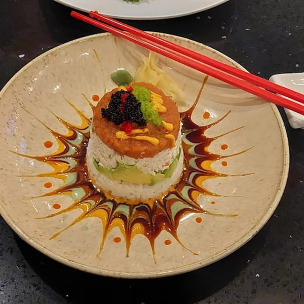 Zato Thai Cuisine & Sushi Bar's sushi tower with avocado, crab, tuna, caviar, and red chopsticks.