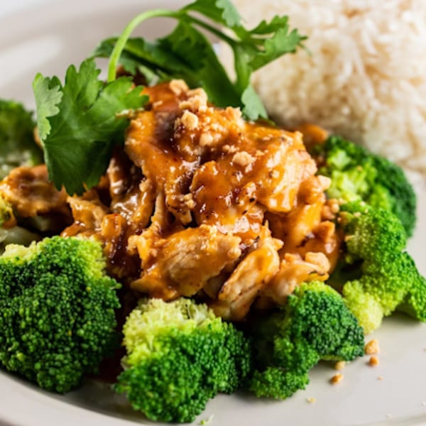 Zato Thai Cuisine's chicken with peanut sauce, broccoli, and white rice on a white plate.