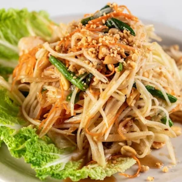 Zato Thai Cuisine's papaya salad, garnished with peanuts, carrots, and green beans, on a bed of lettuce.