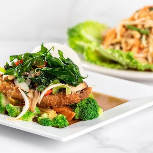 Crispy fried chicken with broccoli, onions, and basil, served with rice and a side salad.